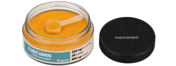 Jar of curcumin supplement with a spoon and 'superdosed' branding on a white background